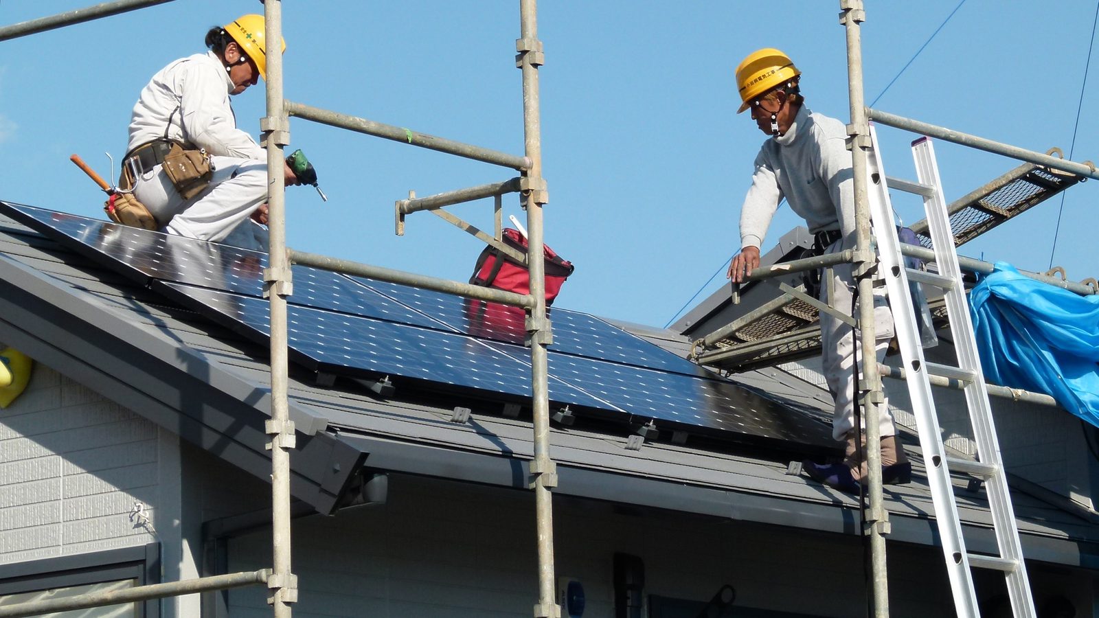 Crew nailing new shingles during a Baltimore roof replacement